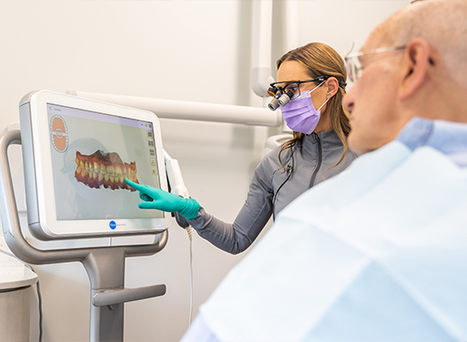 Dentist showing a patient digital impressions of teeth on computer monitor