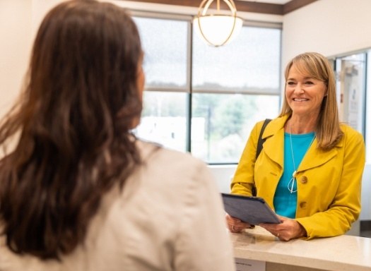 Woman smiling at dental receptionist