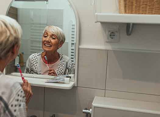 Patient in West Hartford looking in a mirror with dentures